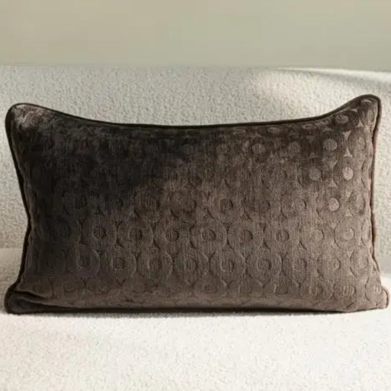 Housse de coussin dans des tons bruns avec motifs de branches, de carreaux et des textures